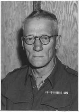 A head-and-shoulders photograph of William E. Fairbairn in 1942, aged fifty-seven, in British battledress with a ribbon bar and round spectacles.