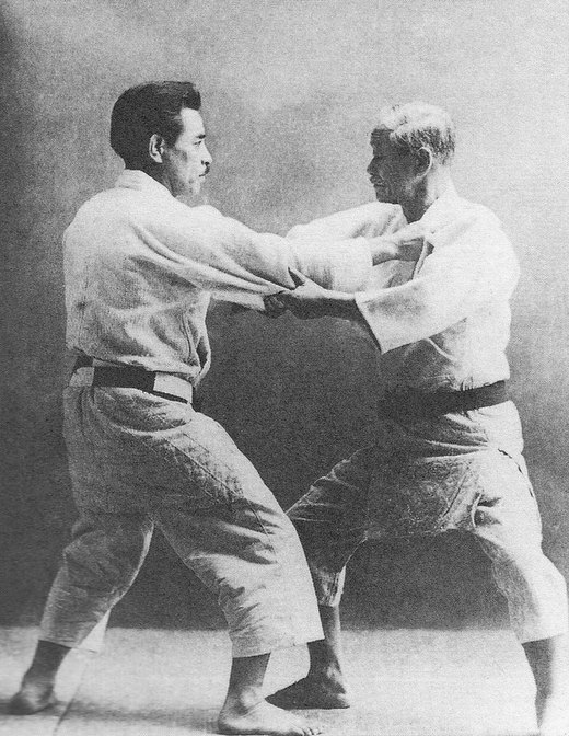 A photograph of Jigoro Kano seated beside Kyuzo Mifune.